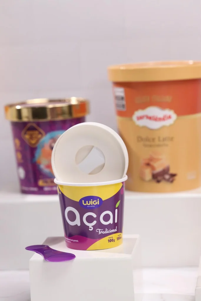 Potinho de açaí com outras opções de sorvetes ao fundo.