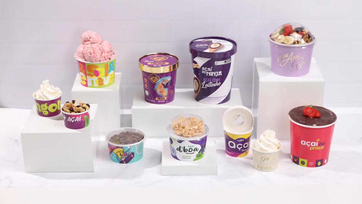 Variedade de copos de iogurte e sorvetes com diferentes sabores e cores, exibidos sobre bases brancas, promovendo as opções para decorar pote de sorvete