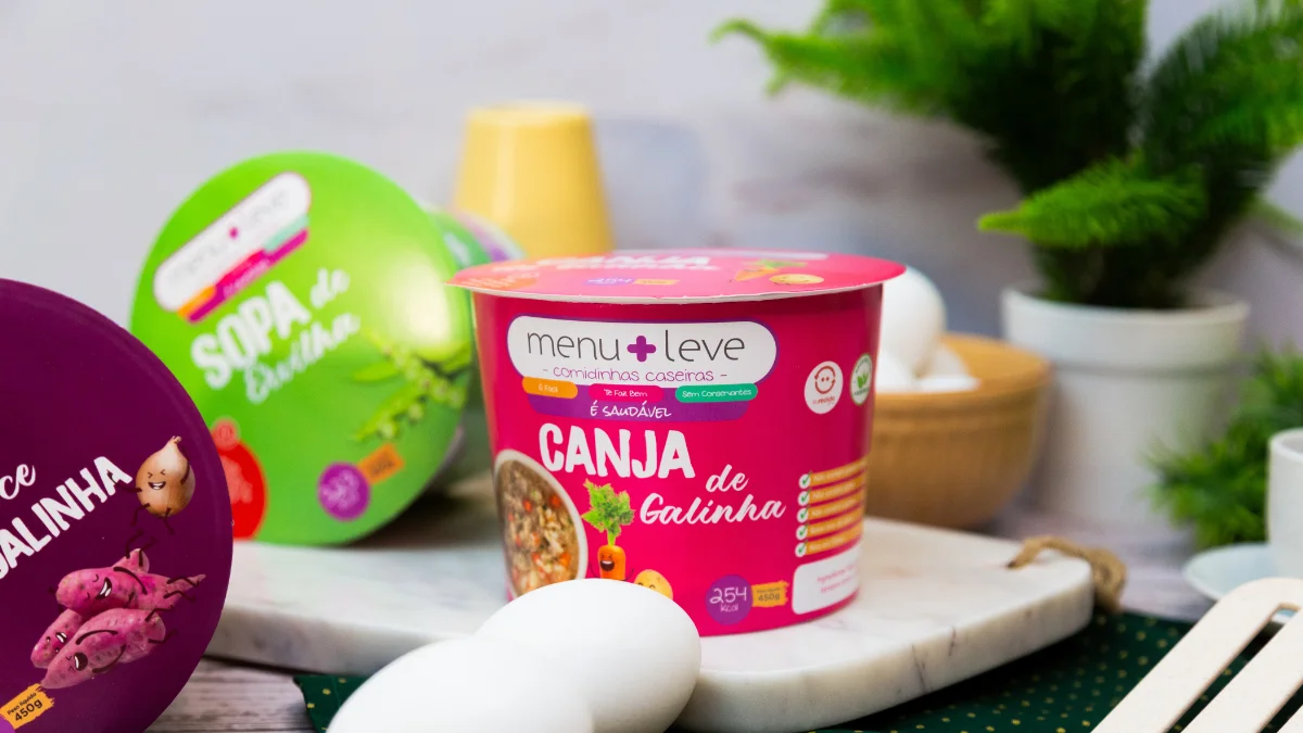 Pote para congelar comida de bebê, segurança e praticidade, com potes de papel coloridos sobre uma mesa, representando as embalagens da Apolo.